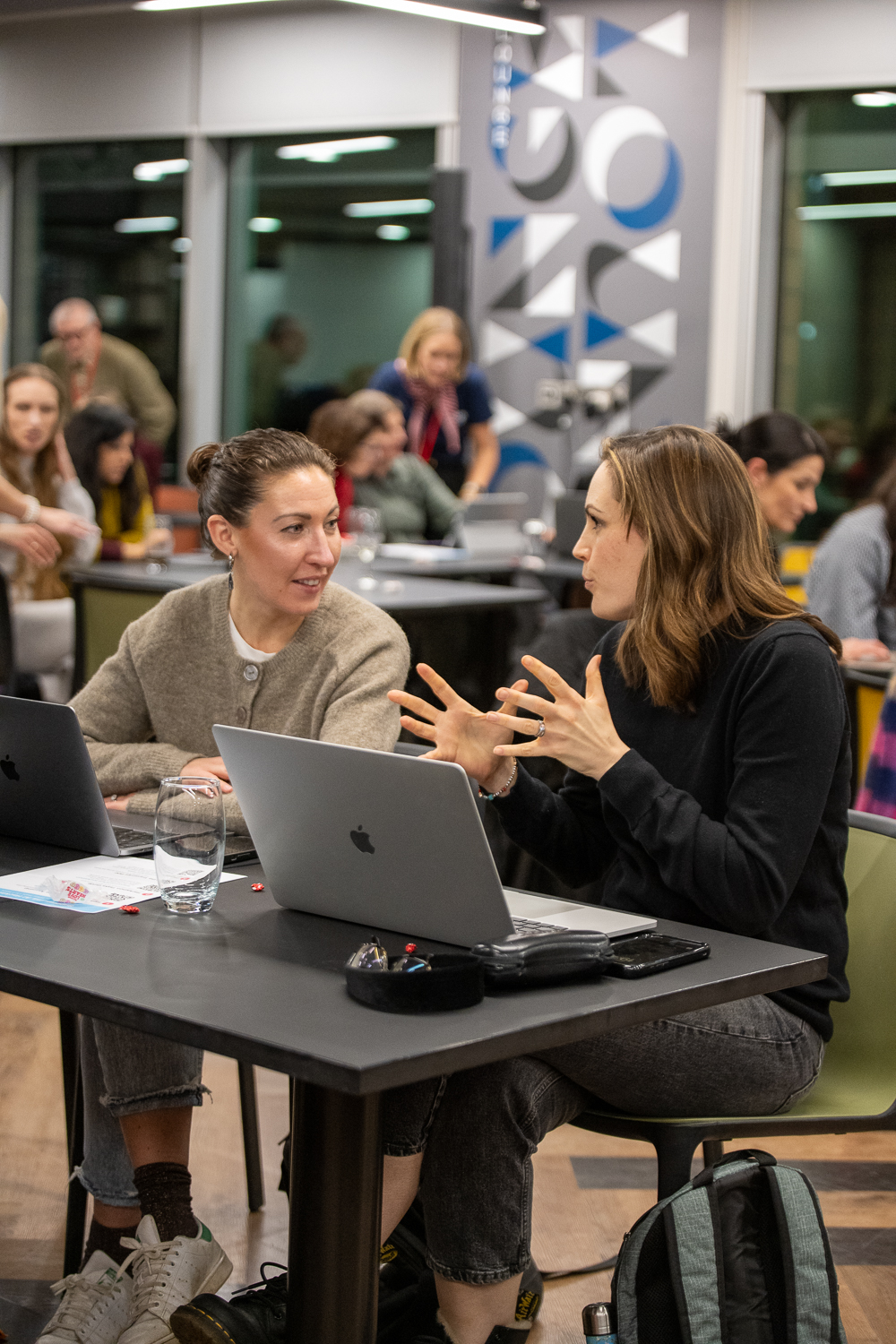 Two women discussing ideas over a laptop at a Supermums training session