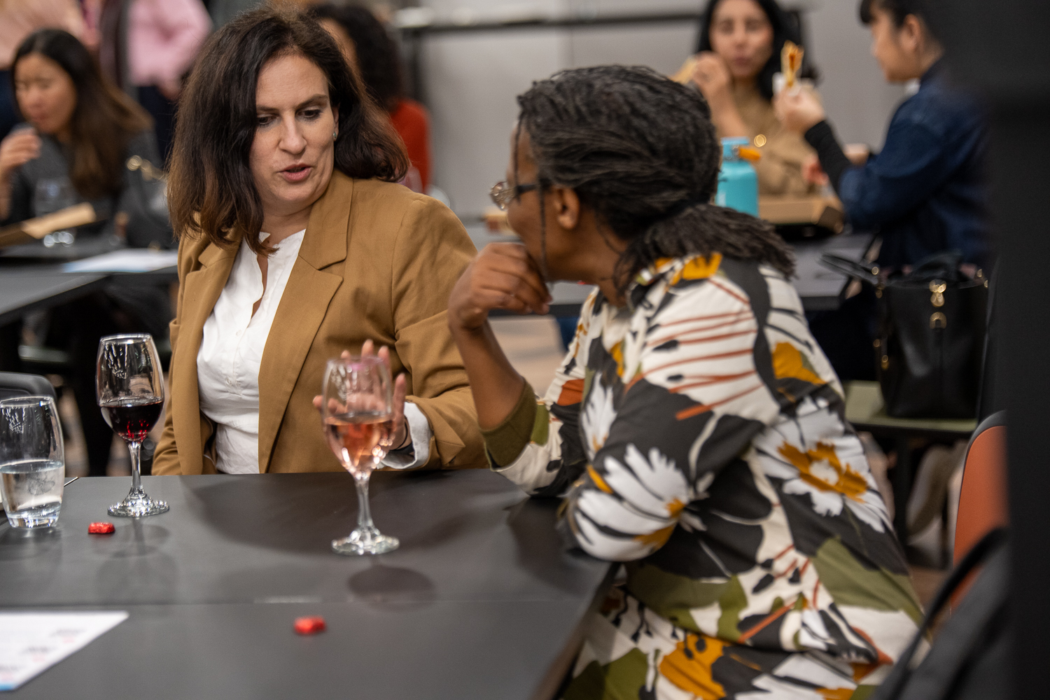 Two women in conversation over a drink at a Supermums event